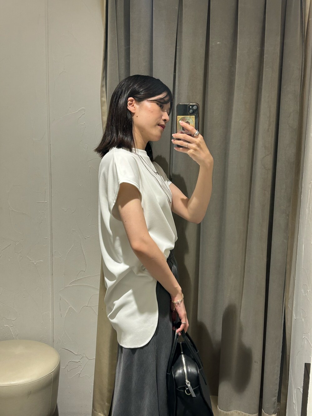 ホワイト系のTシャツ/カットソー、ブラック系のスカート、シルバー系のネックレスを着用したレディースの夏コーディネートの4枚目の写真