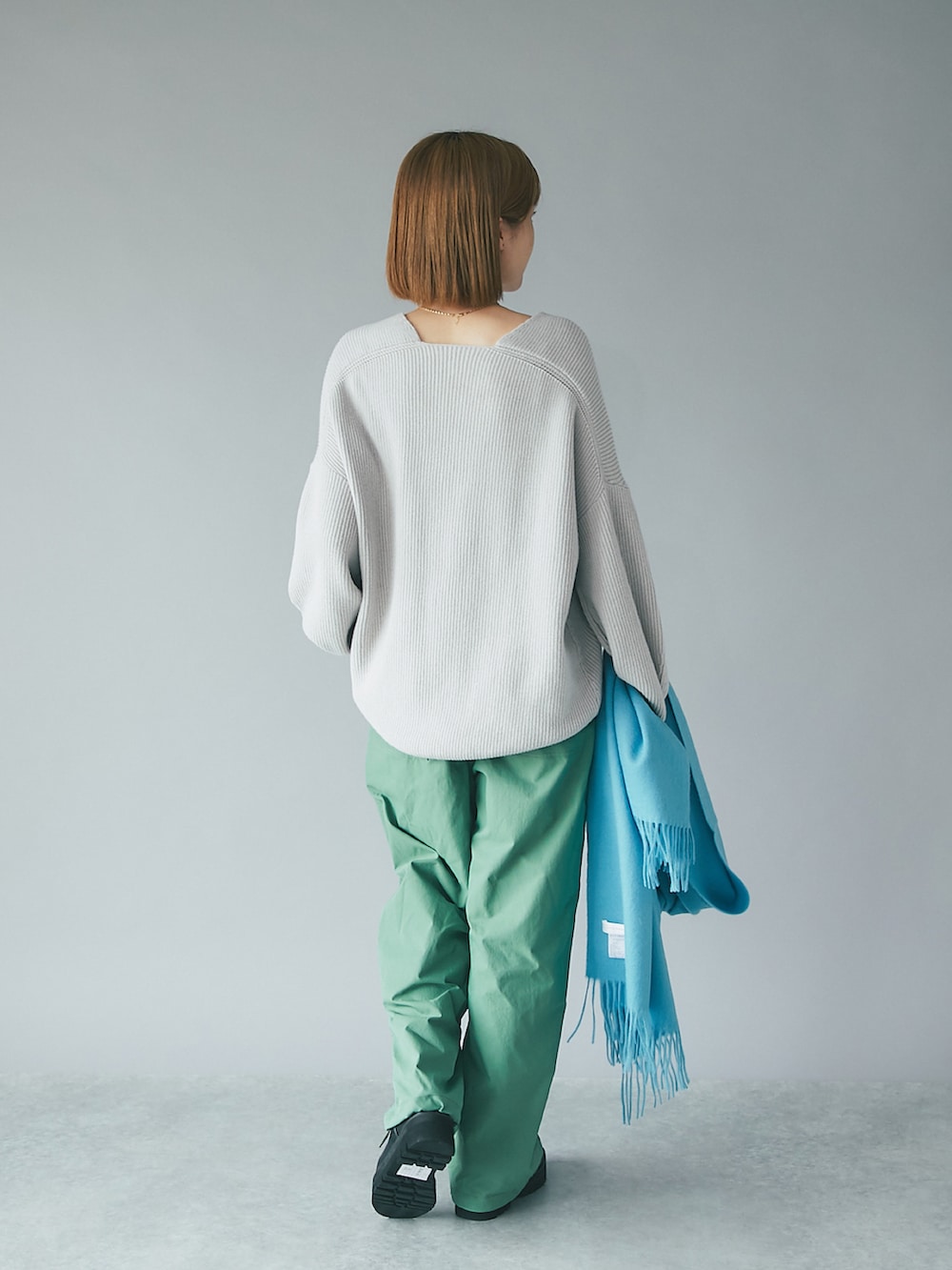 グレー系のニット/セーター、ブラック系のブーツ、グリーン系のその他パンツを着用したレディースの秋コーディネートの3枚目の写真