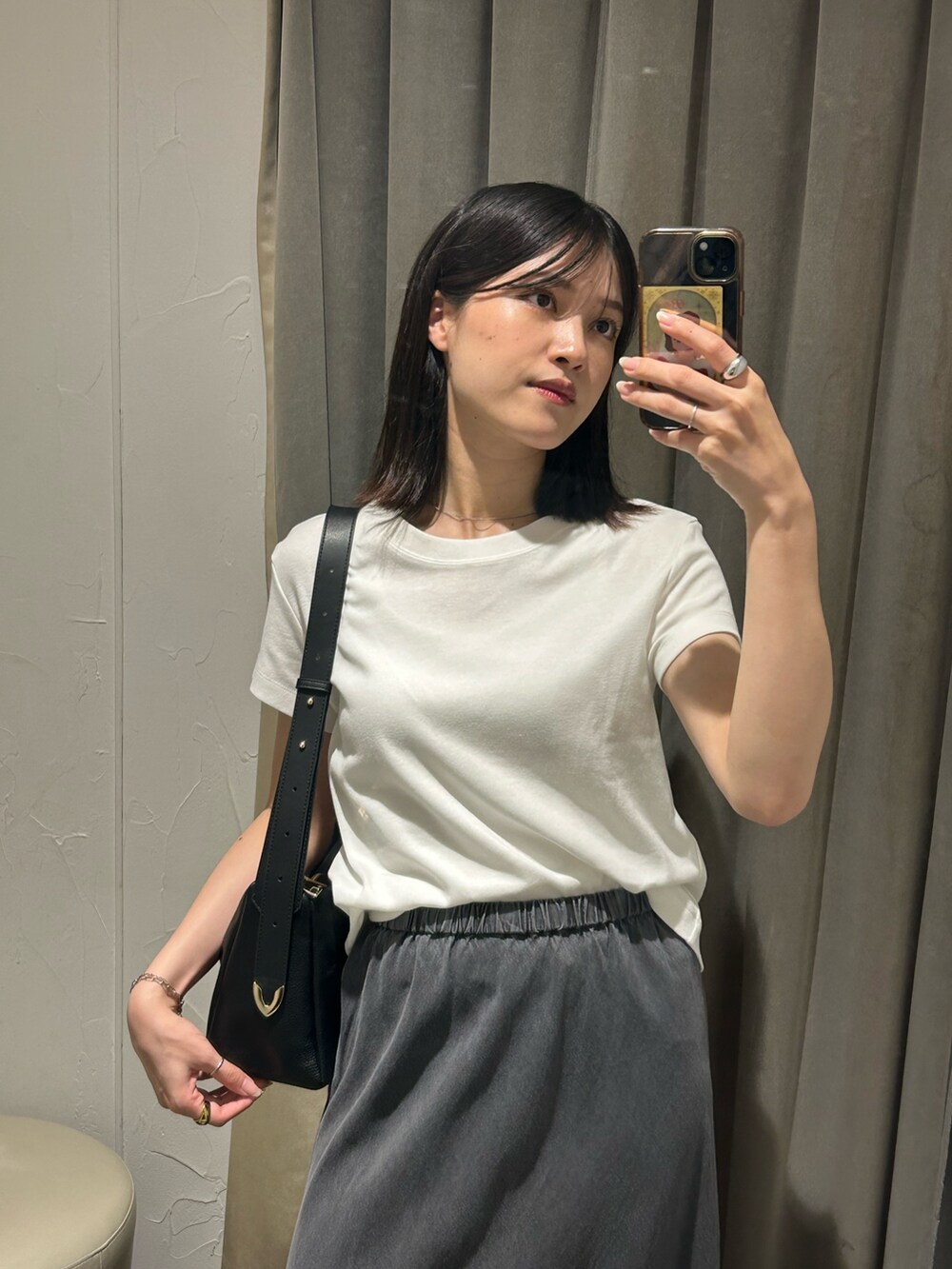 ブラック系のスカート、ブラック系のボディバッグ/ウエストポーチ、ホワイト系のTシャツ/カットソーを着用したレディースの夏コーディネートの3枚目の写真