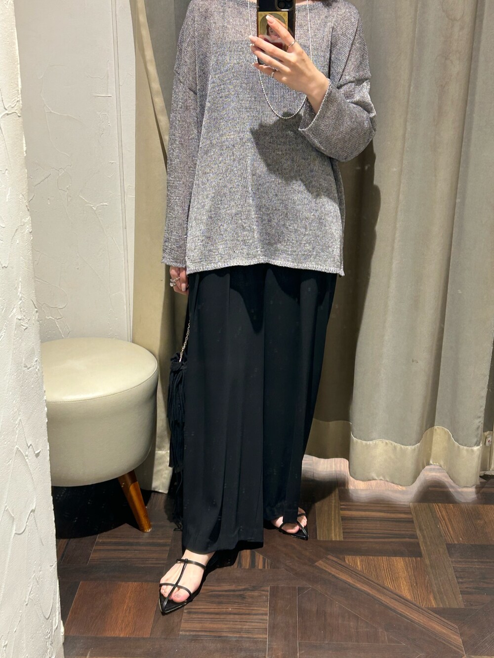 グレー系のニット/セーター、ブラック系のスラックス、シルバー系のネックレスを着用したレディースの夏コーディネートの4枚目の写真