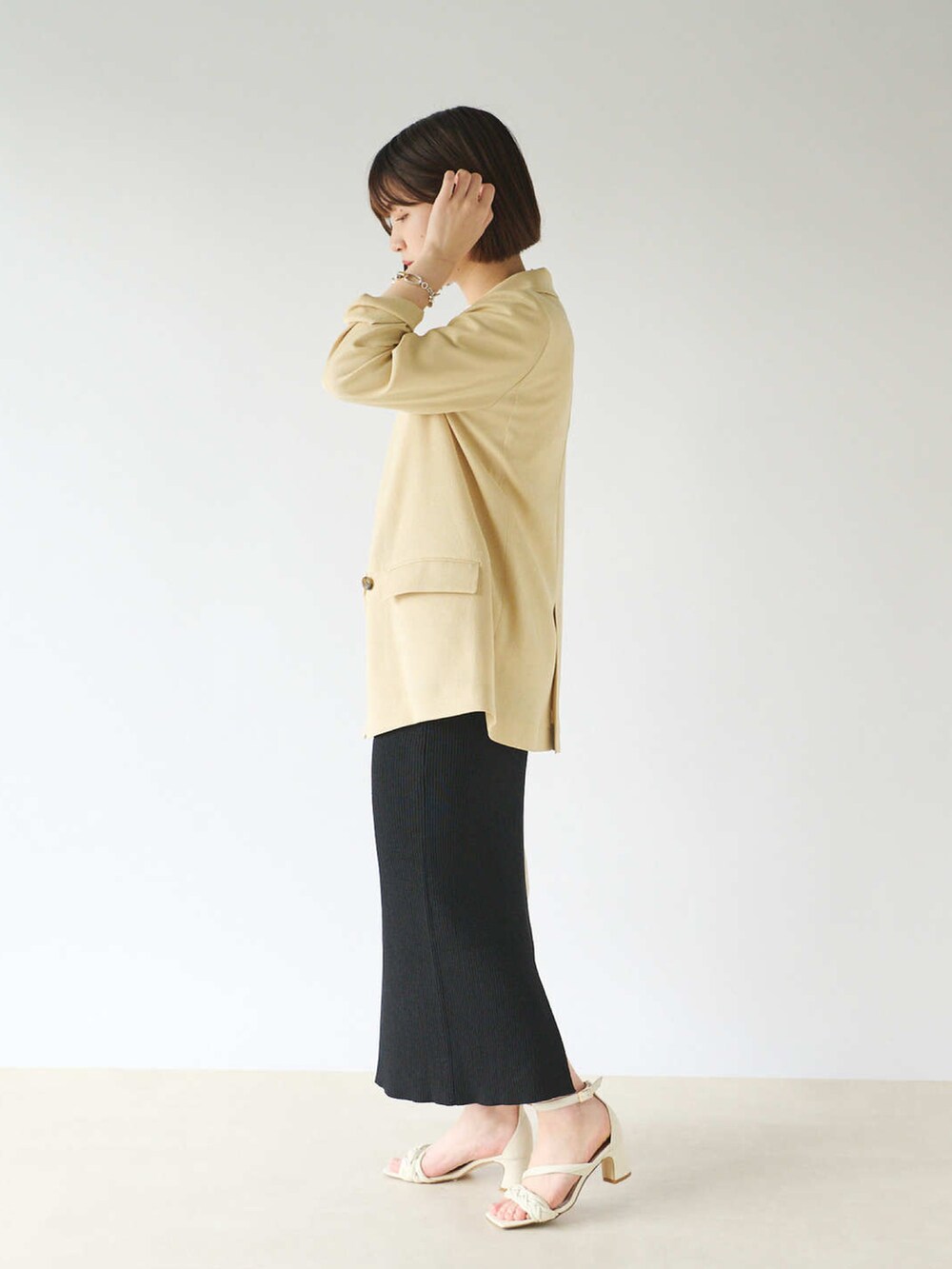 ホワイト系のTシャツ/カットソー、イエロー系のテーラードジャケット、ブラック系のスカートを着用したレディースの春コーディネートの2枚目の写真