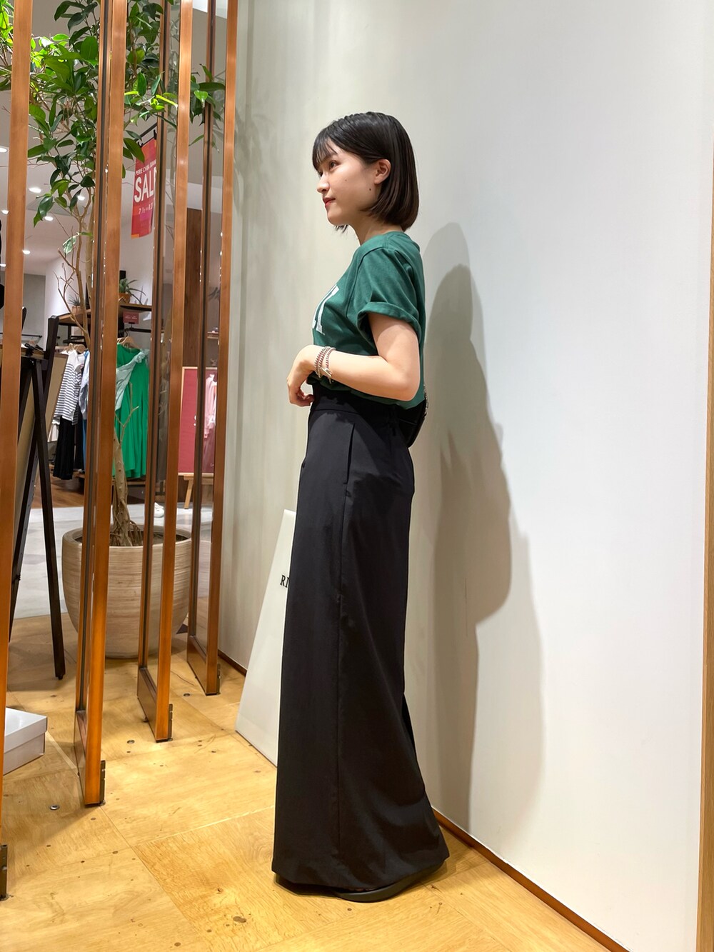 グリーン系のTシャツ/カットソー、ブラック系のショルダーバッグ、ブラック系のスカートを着用したレディースの夏コーディネートの2枚目の写真