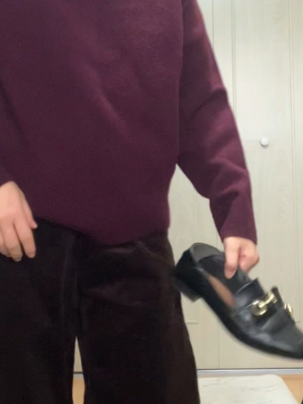 ブラック系のハンドバッグ、レッド系のニット/セーター、ブラウン系のパンツを着用したレディースの冬コーディネートの3枚目の写真