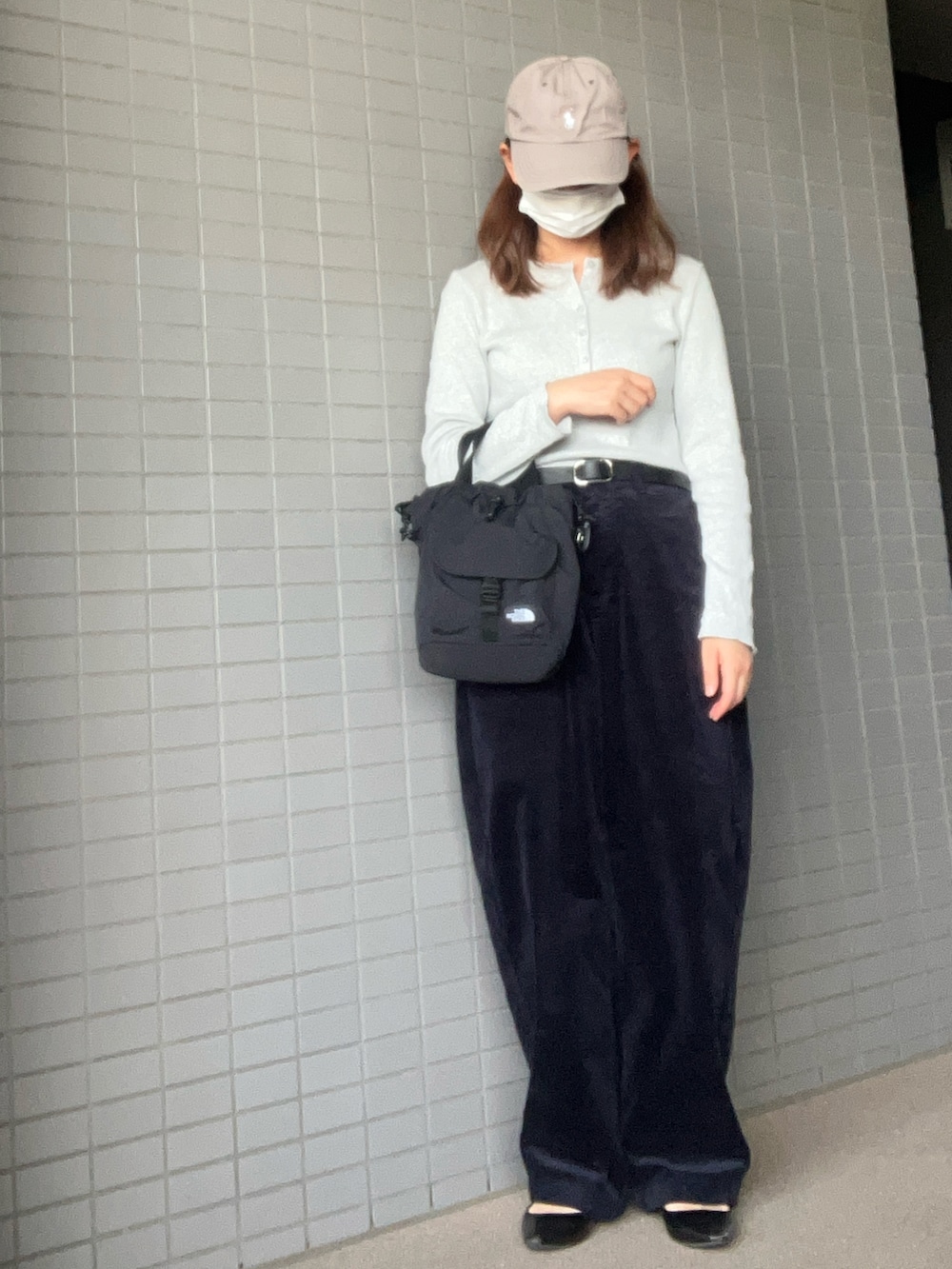 ブラック系のショルダーバッグ、ホワイト系のTシャツ/カットソー、ブルー系のパンツを着用したレディースの秋コーディネートの2枚目の写真