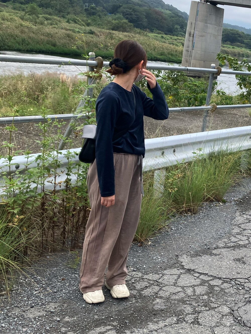 ブラック系のショルダーバッグ、グレー系のスウェットパンツ、ブルー系のTシャツ/カットソーを着用したレディースの秋コーディネートの2枚目の写真