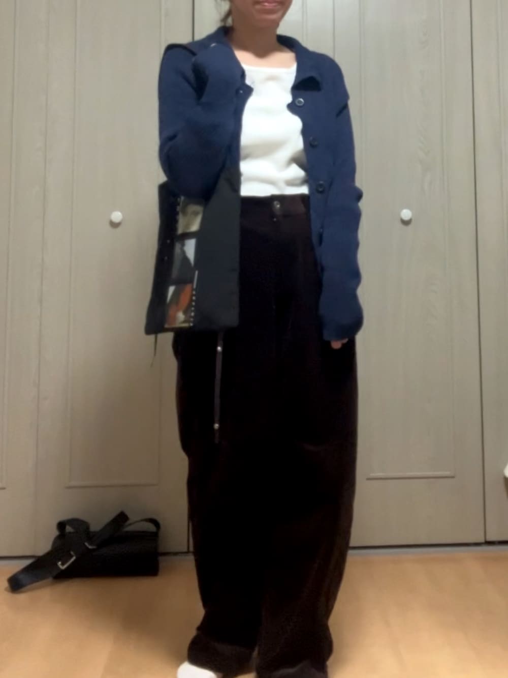 ホワイト系のTシャツ/カットソー、ブルー系のニット/セーター、ブラウン系のパンツを着用したレディースの冬コーディネートの2枚目の写真