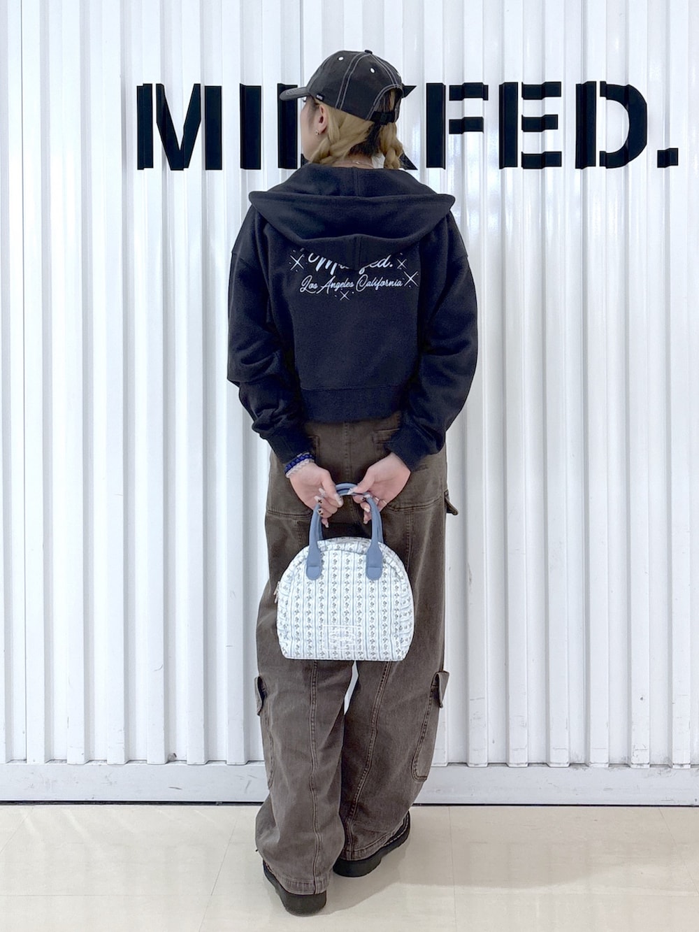 ホワイト系のハンドバッグ、ブラウン系のその他パンツ、ブルー系のキャミソールを着用したレディースの春コーディネートの2枚目の写真