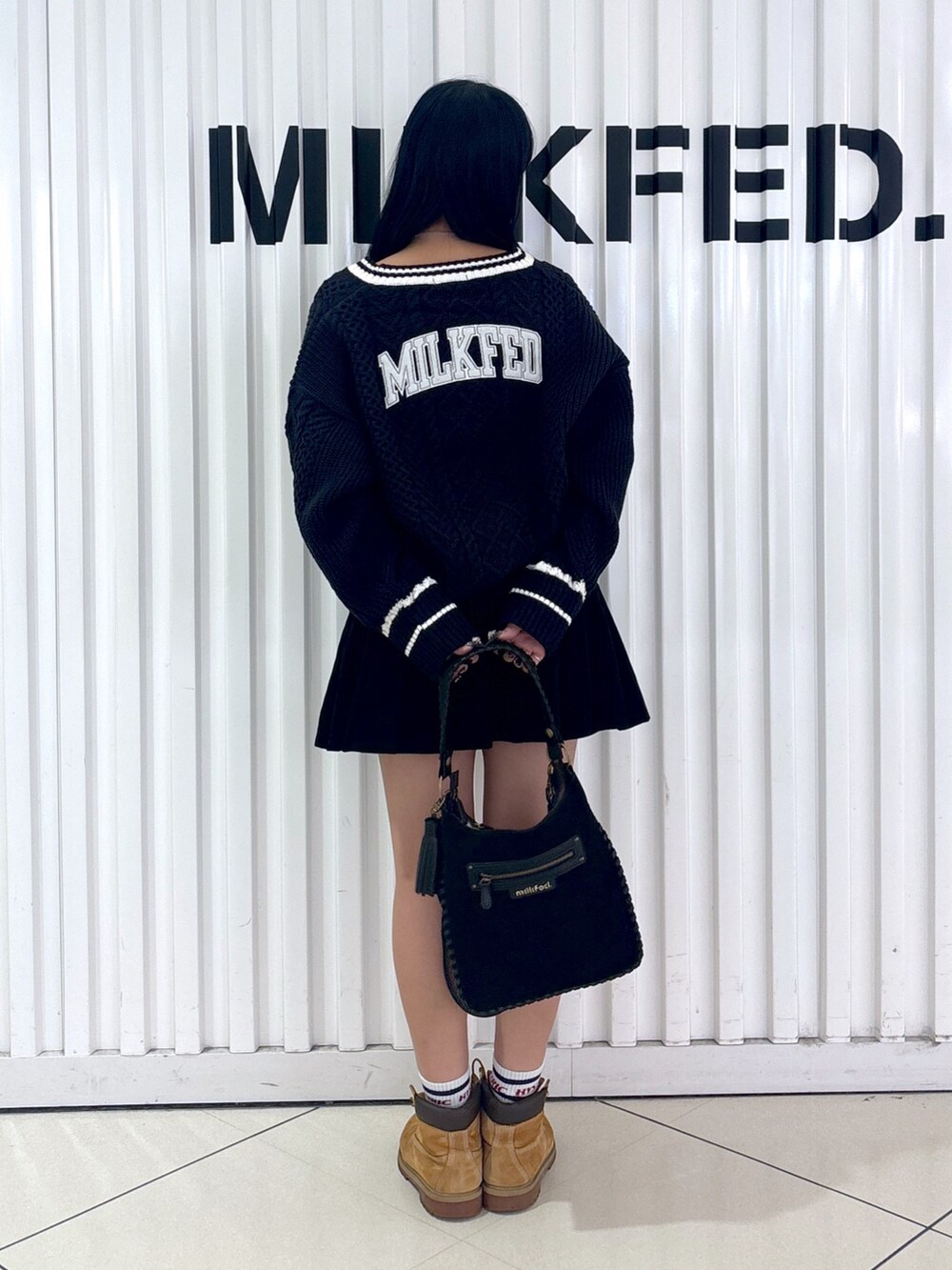 ブラック系のその他パンツ、ブルー系のニット/セーター、ブラック系のショルダーバッグを着用したレディースの秋コーディネートの2枚目の写真