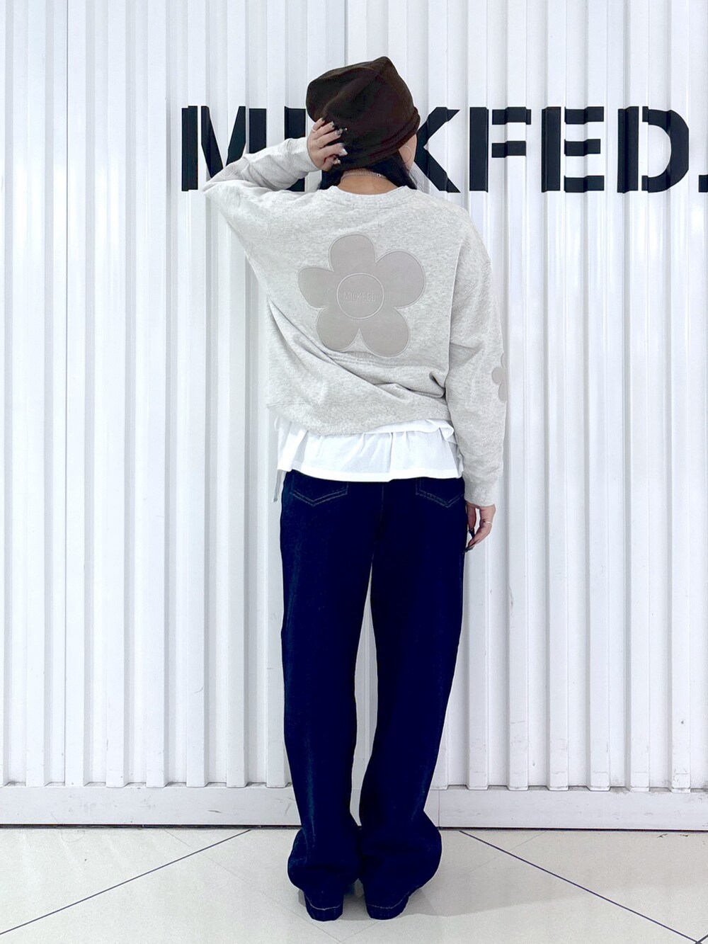 ベージュ系のスウェット、ホワイト系のTシャツ/カットソー、ブルー系のデニムパンツを着用したレディースの秋コーディネートの2枚目の写真