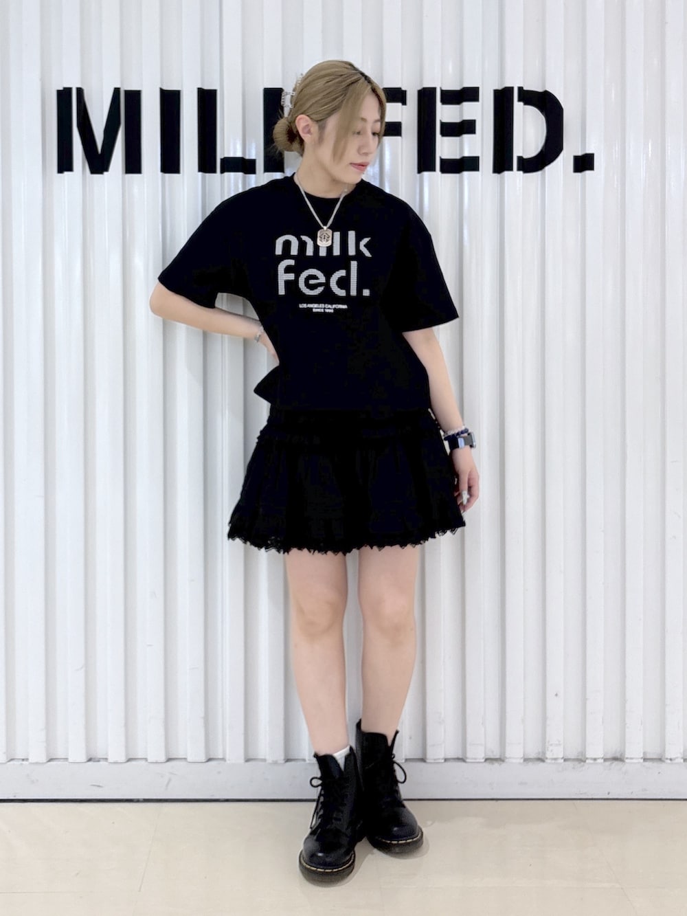 ブラック系のTシャツ/カットソー、ブラック系のスカート、ホワイト系のショルダーバッグを着用したレディースの春コーディネートの3枚目の写真