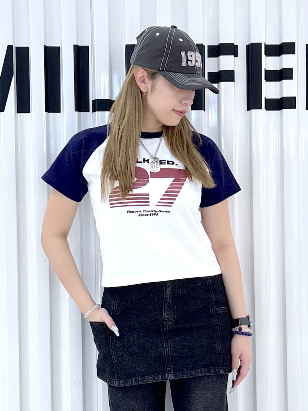 ブラック系のデニムスカート、ブラック系のデニムパンツ、ホワイト系のTシャツ/カットソーを着用したレディースの夏コーディネートの3枚目の写真