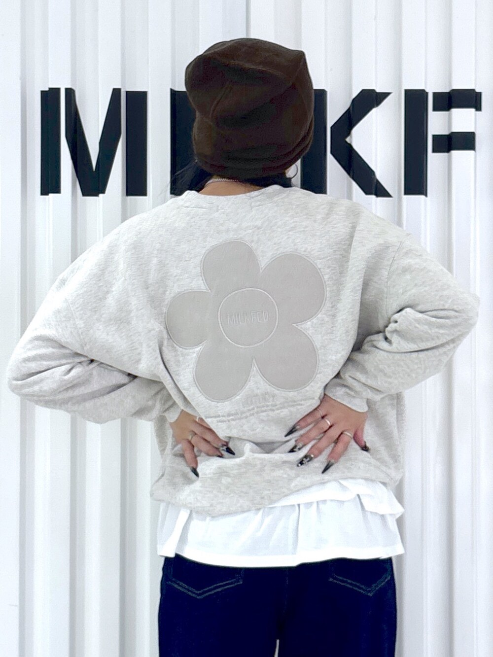 ベージュ系のスウェット、ホワイト系のTシャツ/カットソー、ブルー系のデニムパンツを着用したレディースの秋コーディネートの4枚目の写真