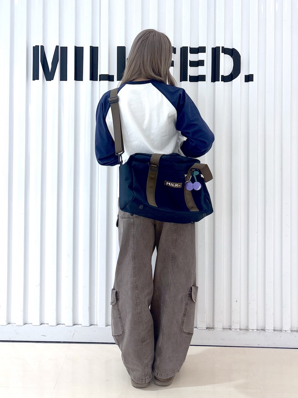 ブラウン系のその他パンツ、ホワイト系のTシャツ/カットソー、ブルー系のショルダーバッグを着用したレディースの冬コーディネートの2枚目の写真