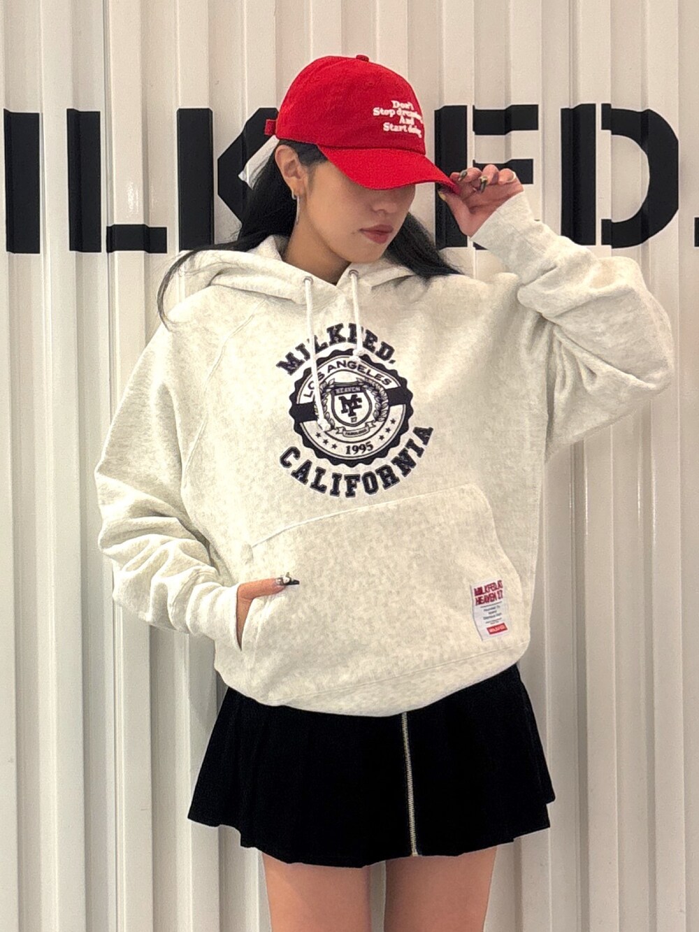 レッド系のパーカー、ブラック系のその他パンツ、ブルー系のキャップを着用したレディースの秋コーディネートの3枚目の写真