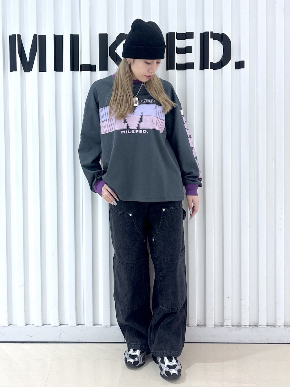 グレー系のTシャツ/カットソー、ブラック系のデニムパンツ、ブルー系のショルダーバッグを着用したレディースの冬コーディネートの3枚目の写真