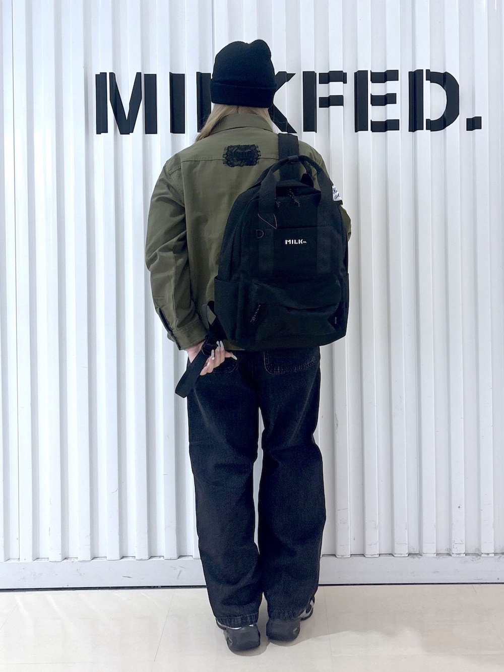 グリーン系のシャツ/ブラウス、ブラック系のデニムパンツ、パープル系のバックパック/リュックを着用したレディースの冬コーディネートの2枚目の写真