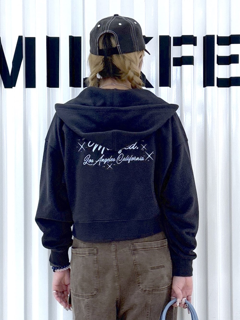 ホワイト系のハンドバッグ、ブラウン系のその他パンツ、ブルー系のキャミソールを着用したレディースの春コーディネートの6枚目の写真