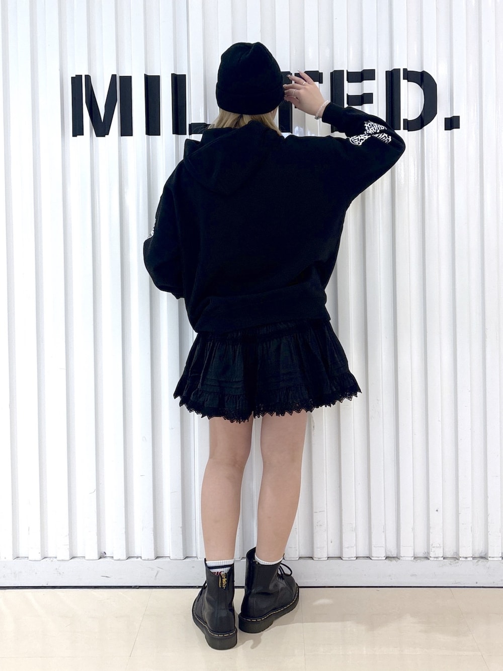 ブラック系のパーカー、ブラック系のスカート、ブラック系のボストンバッグを着用したレディースの春コーディネートの4枚目の写真