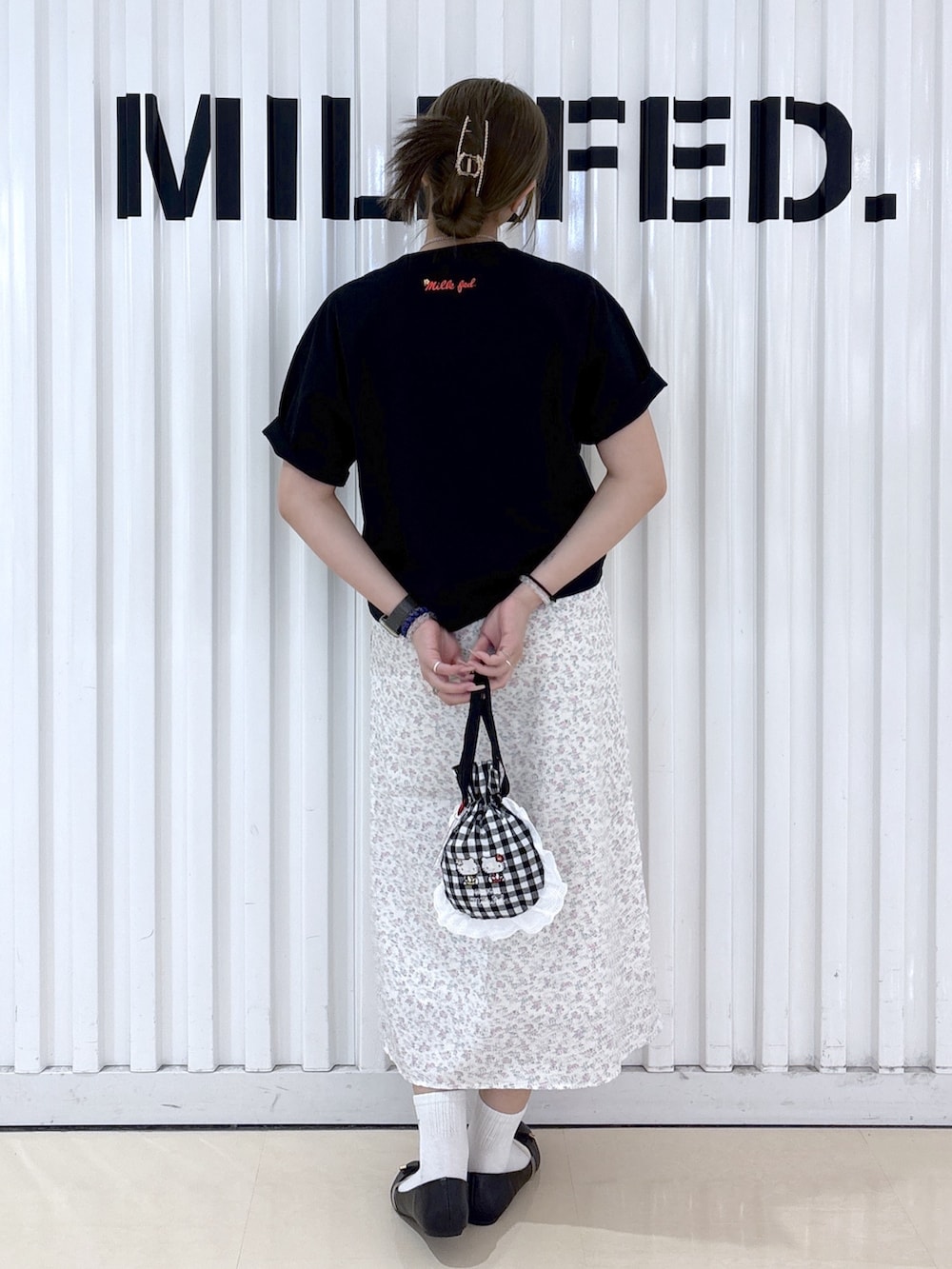 ブラック系のTシャツ/カットソー、ホワイト系のワンピース、ブラック系のポーチを着用したレディースの春コーディネートの2枚目の写真
