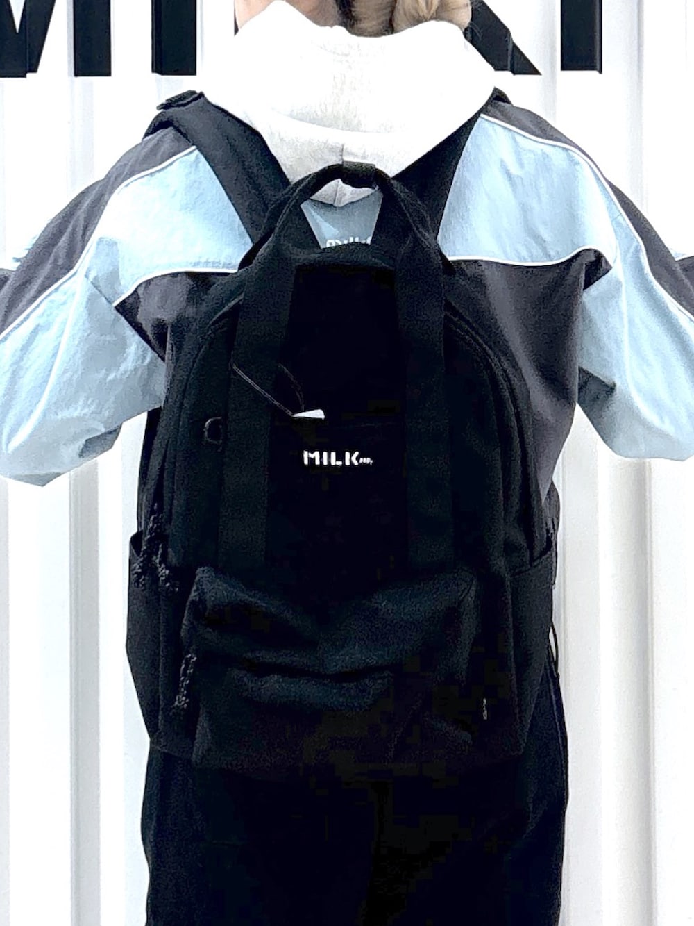 グレー系のナイロンジャケット、ベージュ系のパーカー、ブラック系のスウェットパンツを着用したレディースの春コーディネートの3枚目の写真