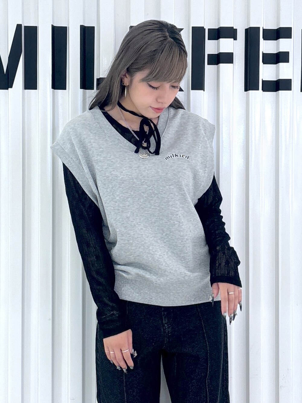 ブラック系のデニムパンツ、グレー系のベスト、ブラック系のTシャツ/カットソーを着用したレディースの秋コーディネートの3枚目の写真