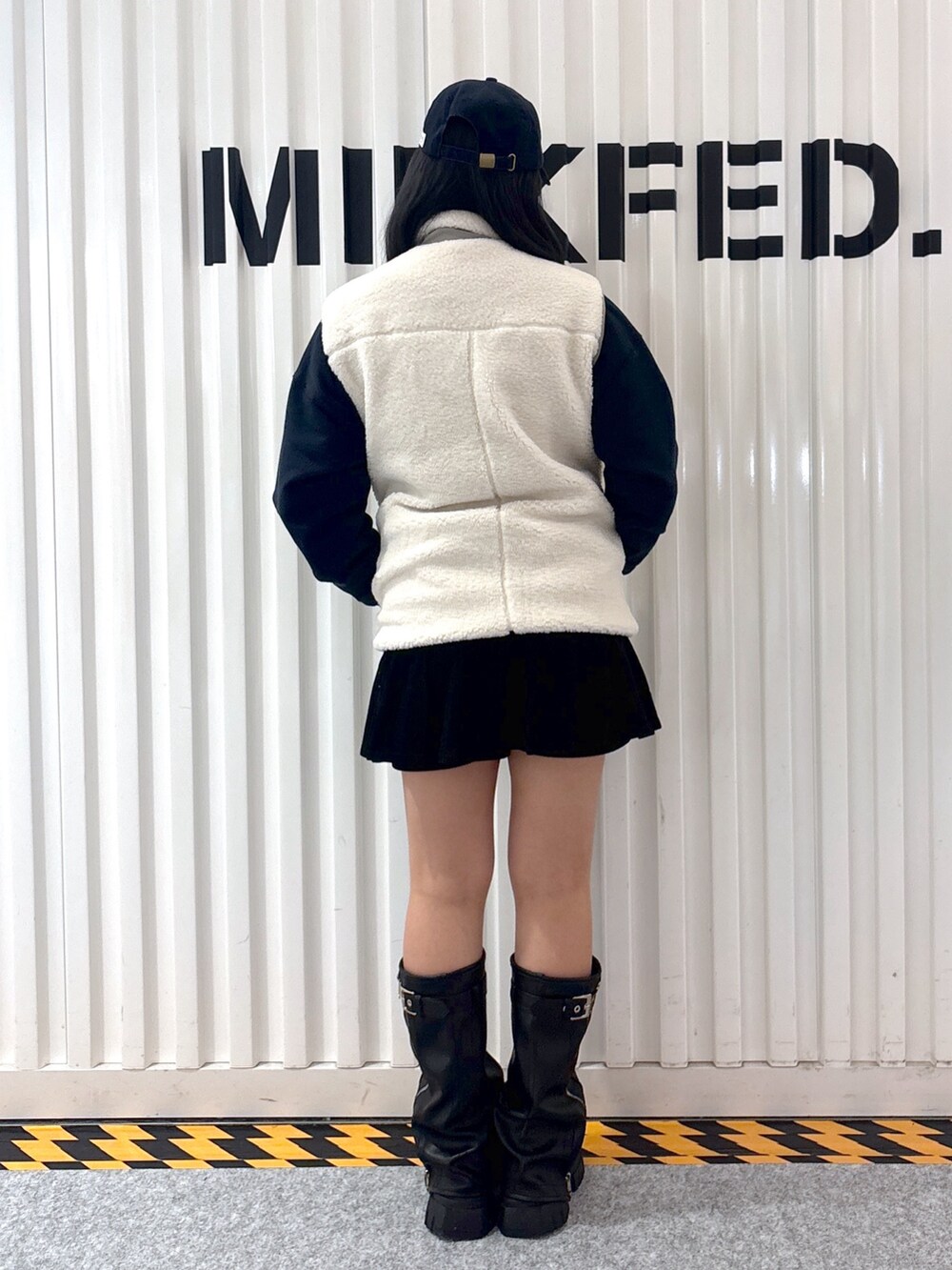 レッド系のスウェット、ホワイト系のベスト、ブラック系のその他パンツを着用したレディースの秋コーディネートの5枚目の写真
