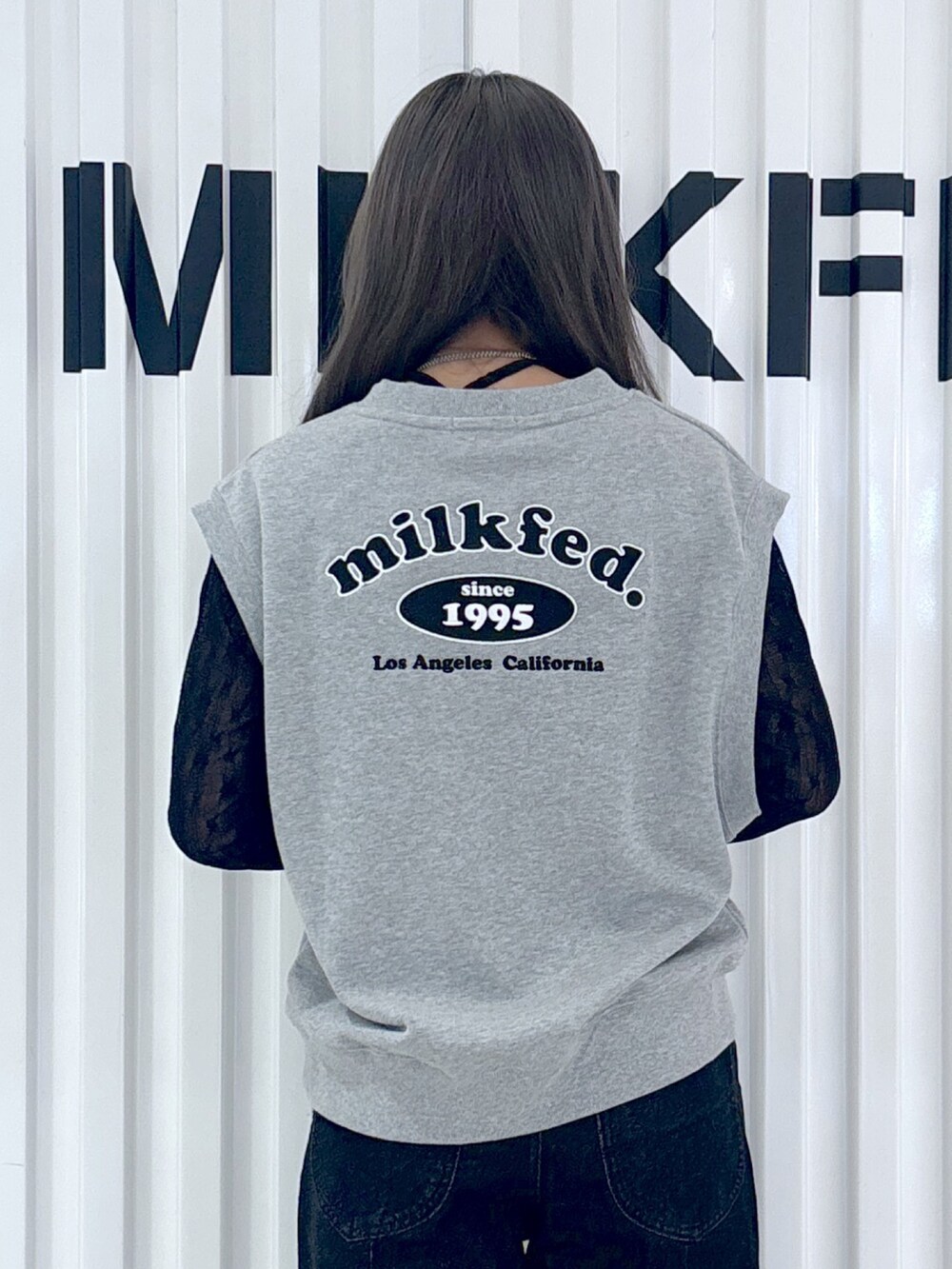 ブラック系のデニムパンツ、グレー系のベスト、ブラック系のTシャツ/カットソーを着用したレディースの秋コーディネートの4枚目の写真