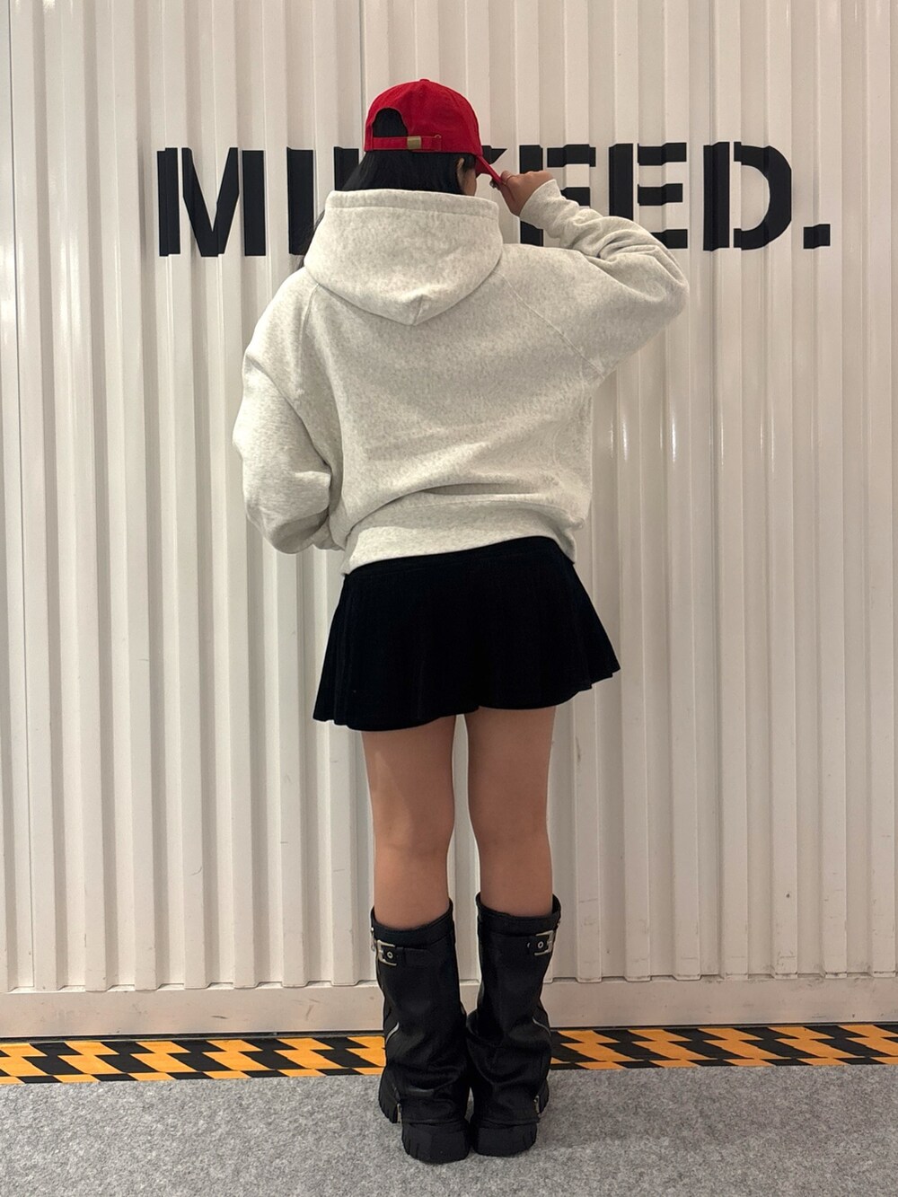 レッド系のパーカー、ブラック系のその他パンツ、ブルー系のキャップを着用したレディースの秋コーディネートの2枚目の写真