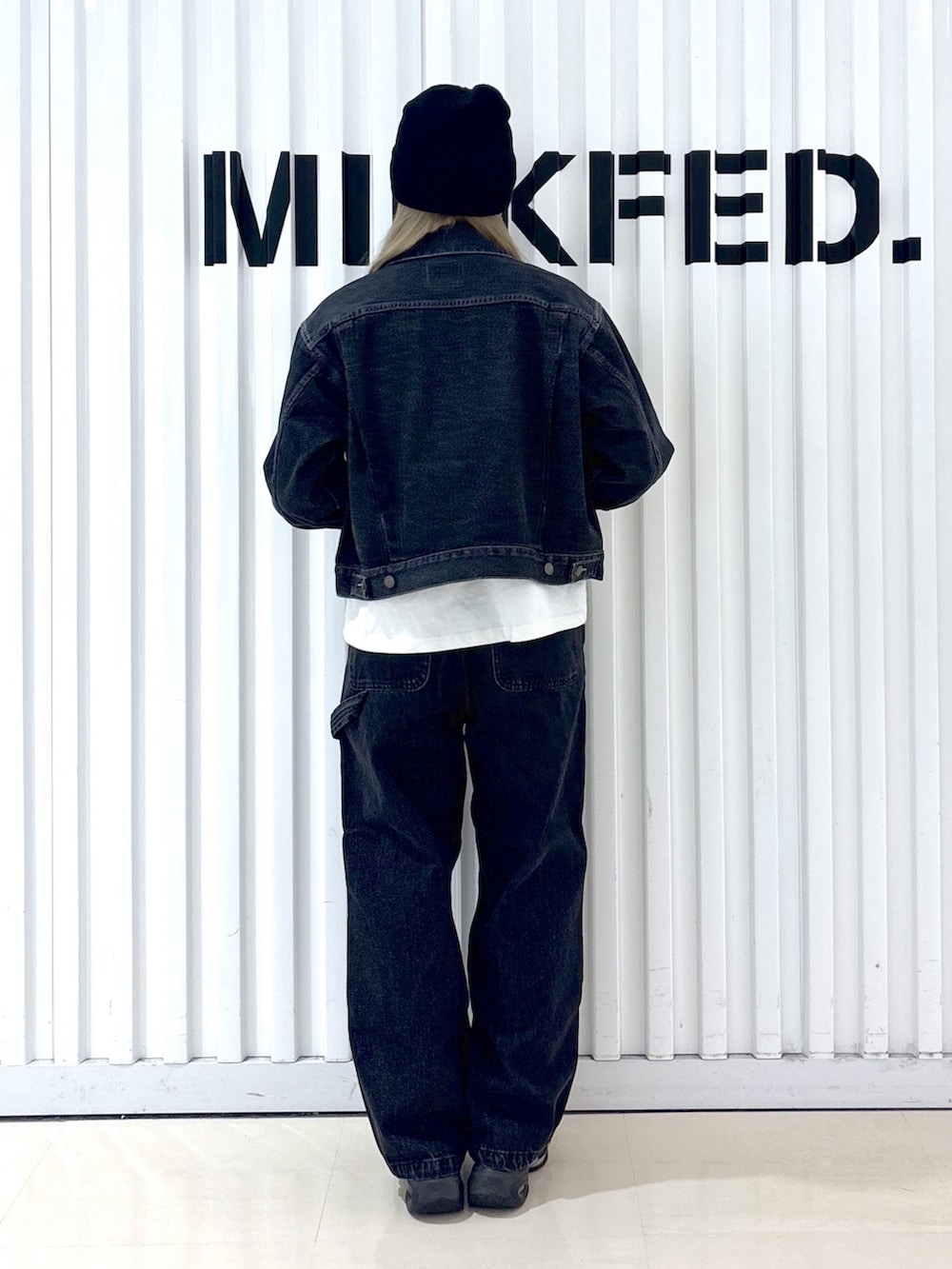 ブラック系のデニムジャケット、ブラック系のデニムパンツ、ホワイト系のTシャツ/カットソーを着用したレディースの冬コーディネートの7枚目の写真