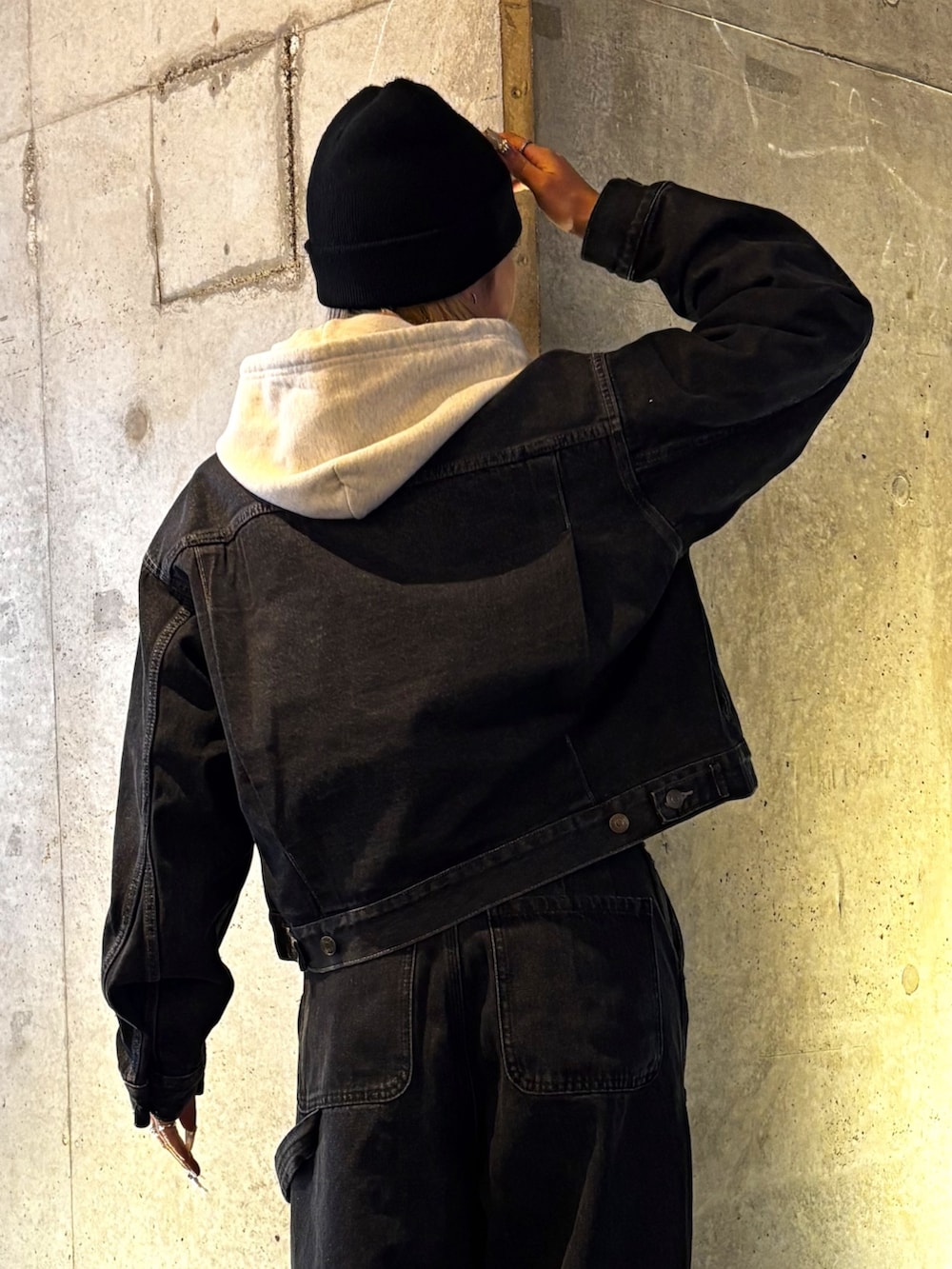 ベージュ系のパーカー、ブラック系のデニムパンツ、ブラック系のデニムジャケットを着用したレディースの春コーディネートの4枚目の写真