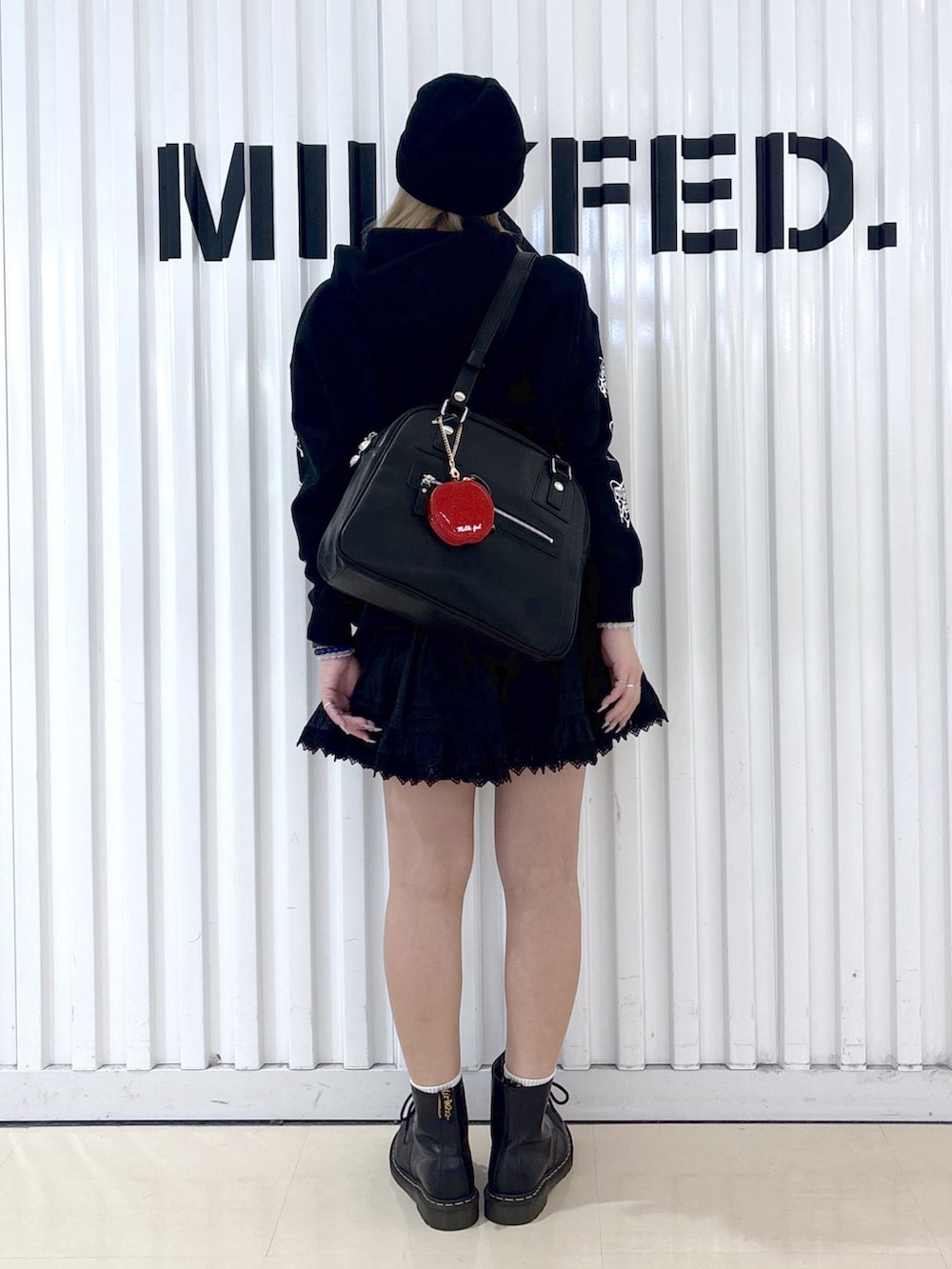 ブラック系のパーカー、ブラック系のスカート、ブラック系のボストンバッグを着用したレディースの春コーディネートの2枚目の写真