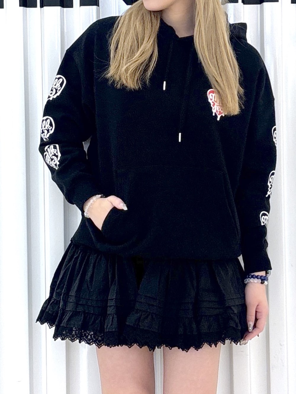 ブラック系のパーカー、ブラック系のスカート、ブラック系のボストンバッグを着用したレディースの春コーディネートの5枚目の写真