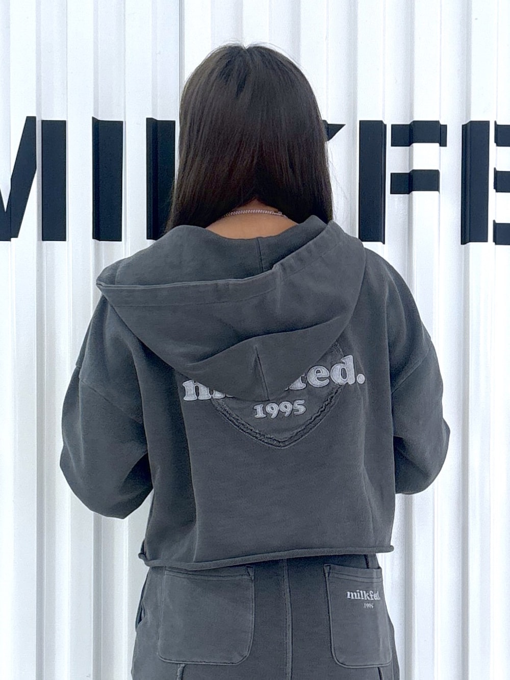 ブラック系のパーカー、ブラック系のスカートを着用したレディースの冬コーディネートの3枚目の写真