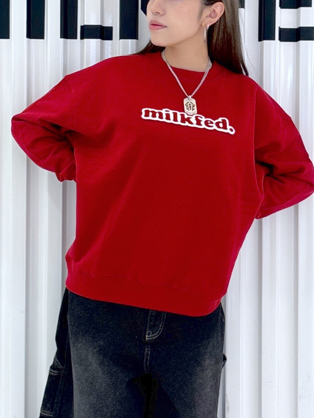 レッド系のスウェット、ホワイト系のデニムパンツ、レッド系のバックパック/リュックを着用したレディースの秋コーディネートの6枚目の写真