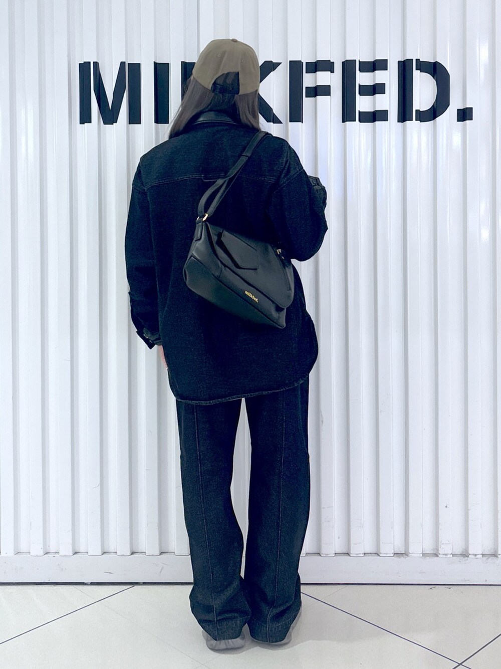 ブラック系のシャツ/ブラウス、ブラック系のデニムパンツ、ブラック系のショルダーバッグを着用したレディースの秋コーディネートの2枚目の写真