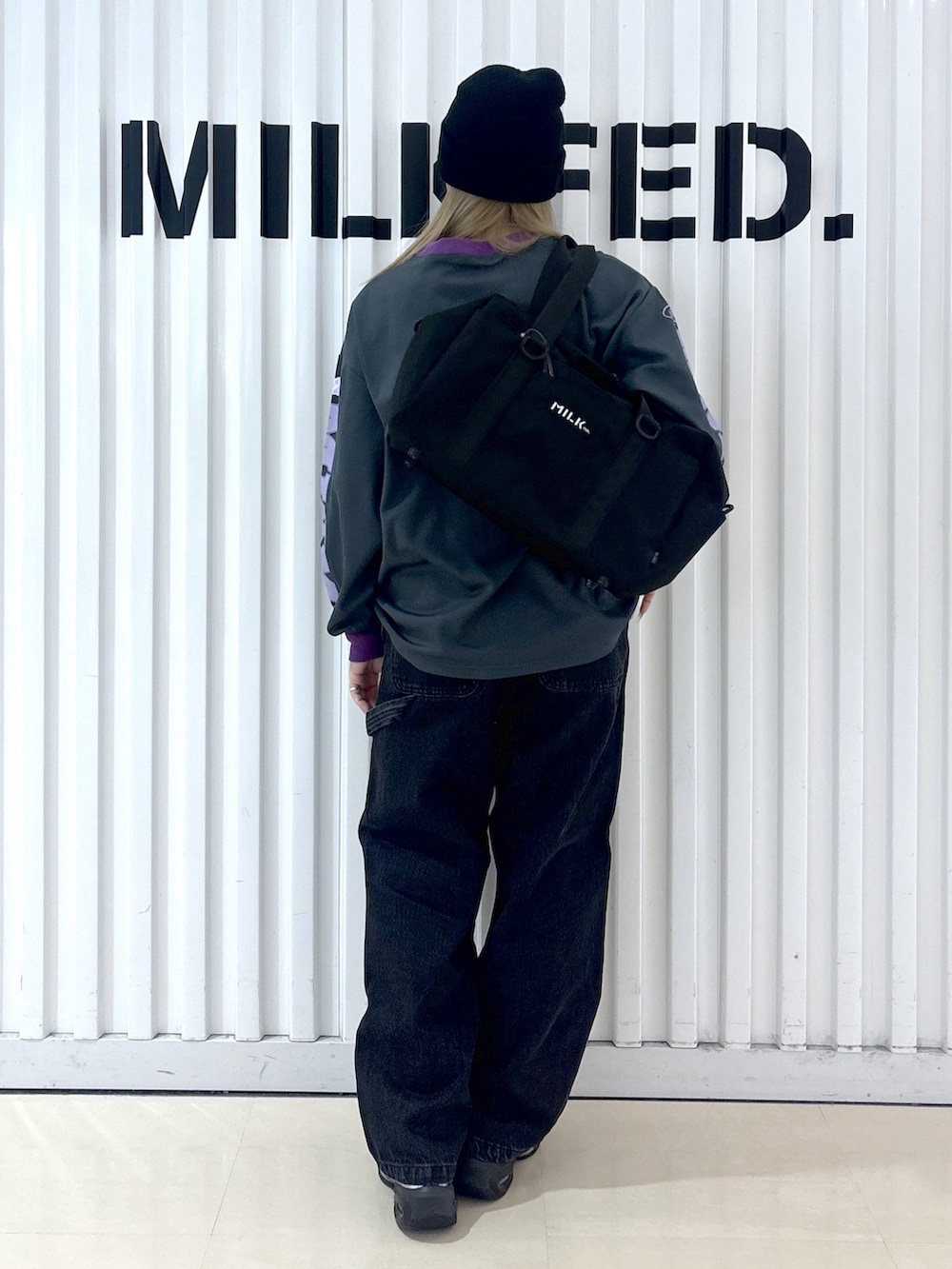 グレー系のTシャツ/カットソー、ブラック系のデニムパンツ、ブルー系のショルダーバッグを着用したレディースの冬コーディネートの2枚目の写真