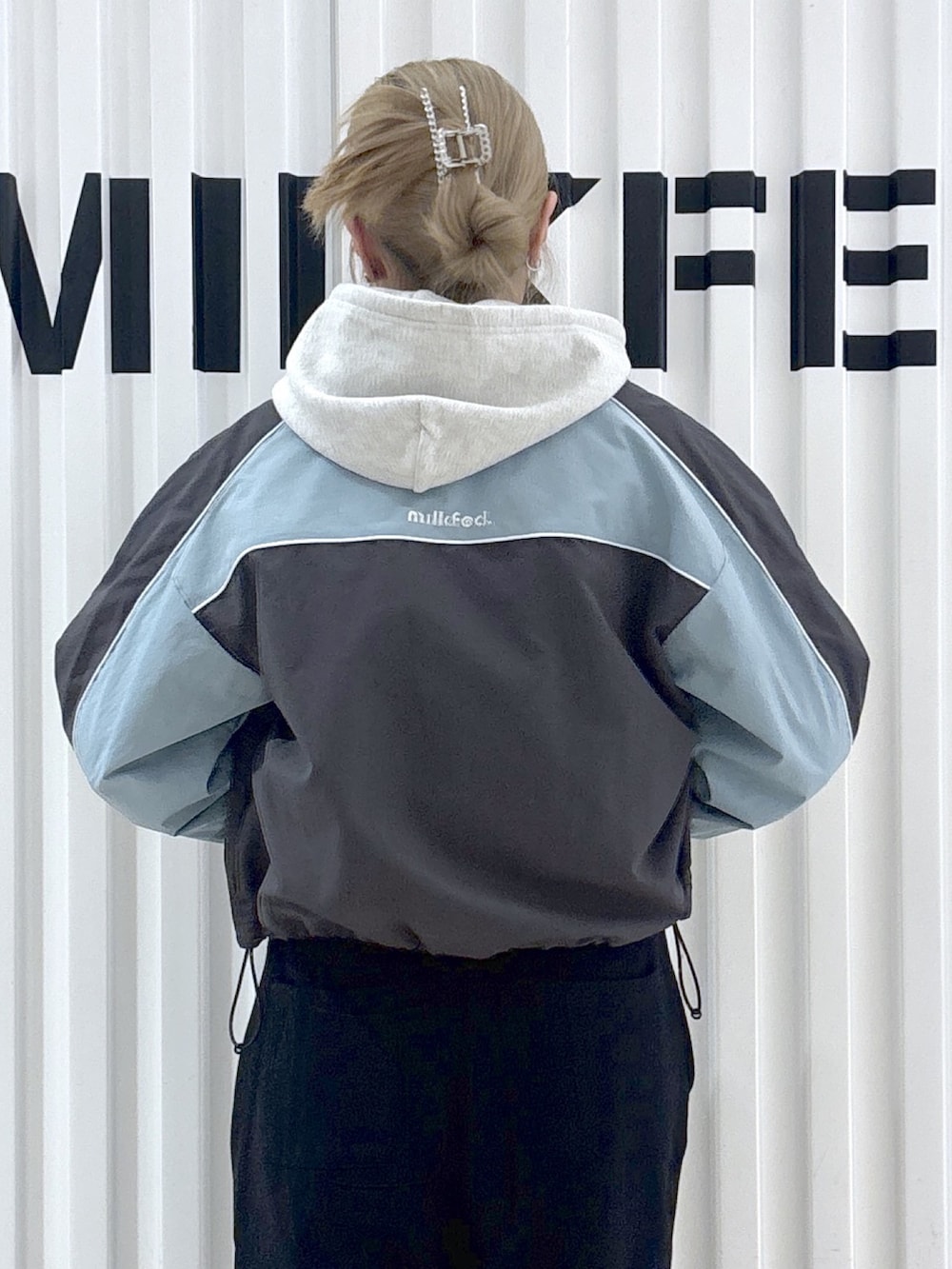 グレー系のナイロンジャケット、ベージュ系のパーカー、ブラック系のスウェットパンツを着用したレディースの春コーディネートの7枚目の写真