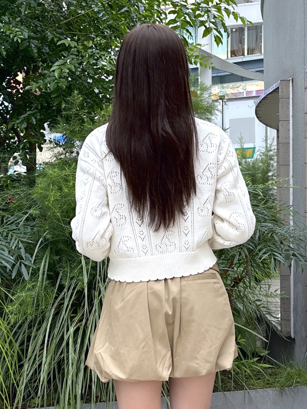 ホワイト系のカーディガン/ボレロ、グレー系のTシャツ/カットソー、ベージュ系のスカートを着用したレディースの秋コーディネートの4枚目の写真