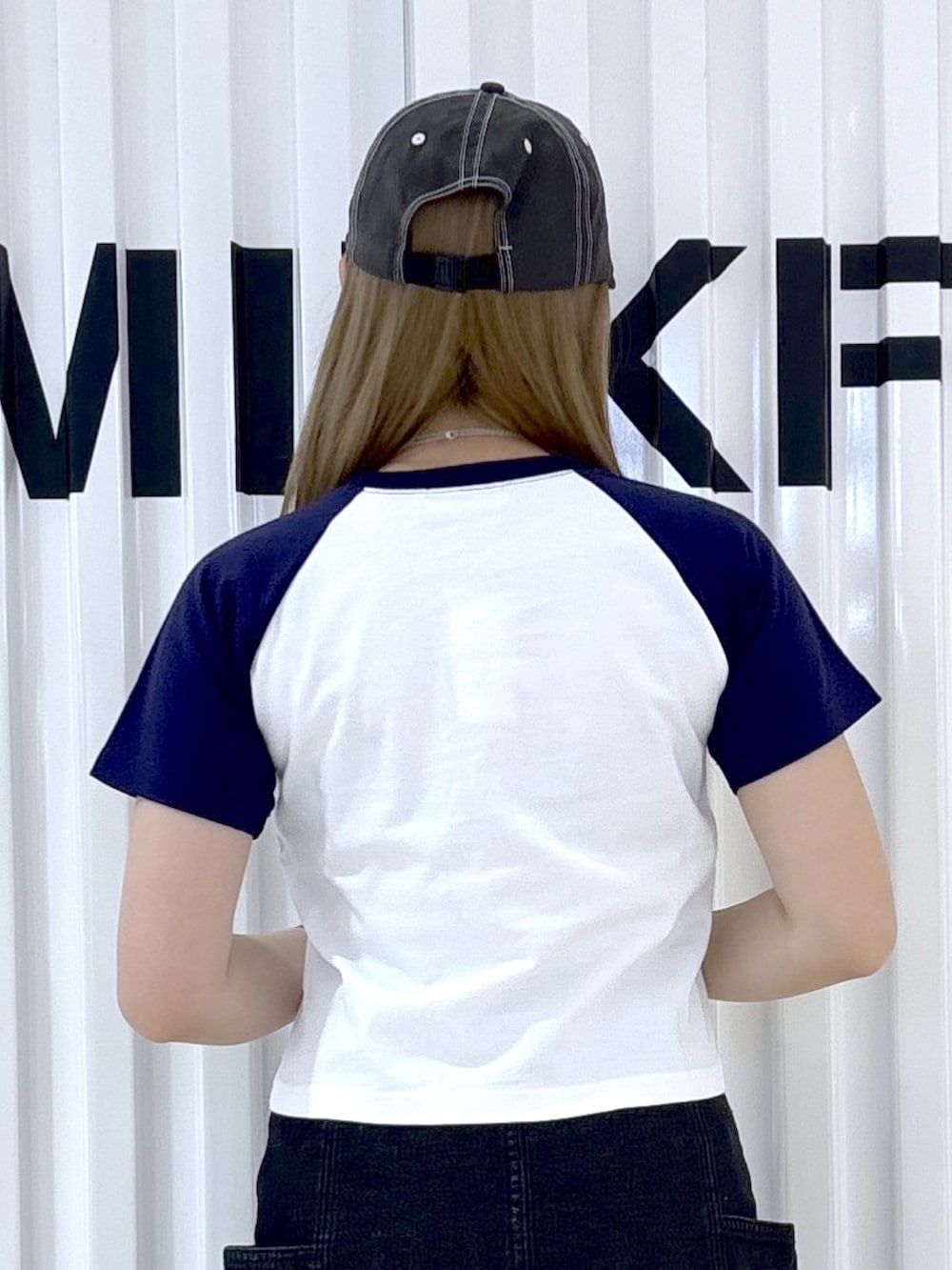ブラック系のデニムスカート、ブラック系のデニムパンツ、ホワイト系のTシャツ/カットソーを着用したレディースの夏コーディネートの4枚目の写真