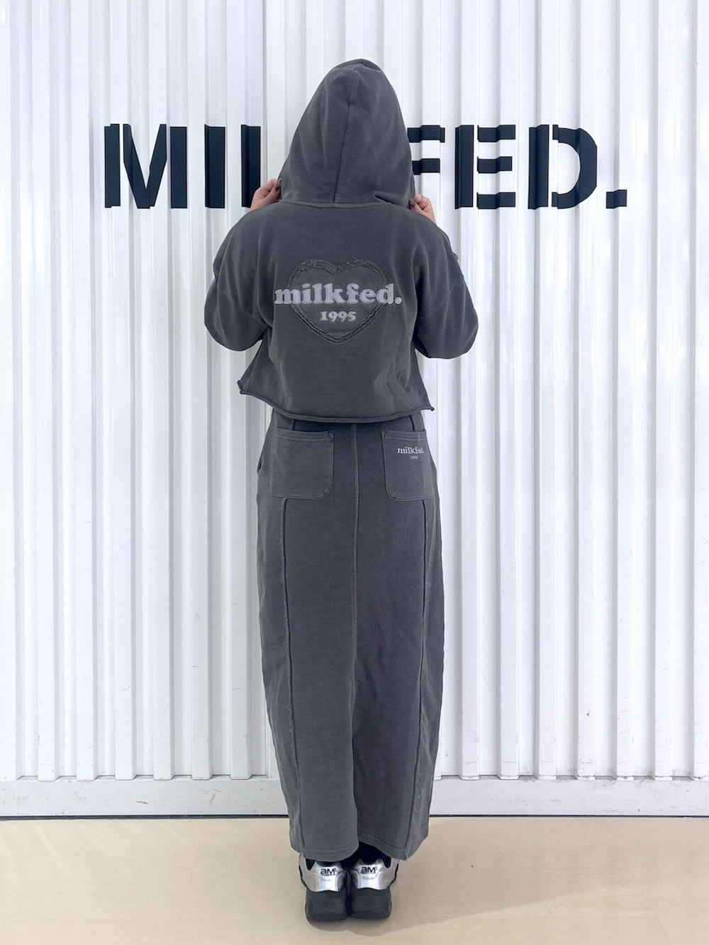 ブラック系のパーカー、ブラック系のスカートを着用したレディースの冬コーディネートの5枚目の写真