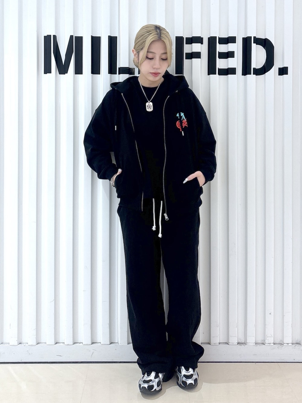 ブラック系のパーカー、ブラック系のTシャツ/カットソー、ブラック系のスウェットパンツを着用したレディースの春コーディネートの5枚目の写真