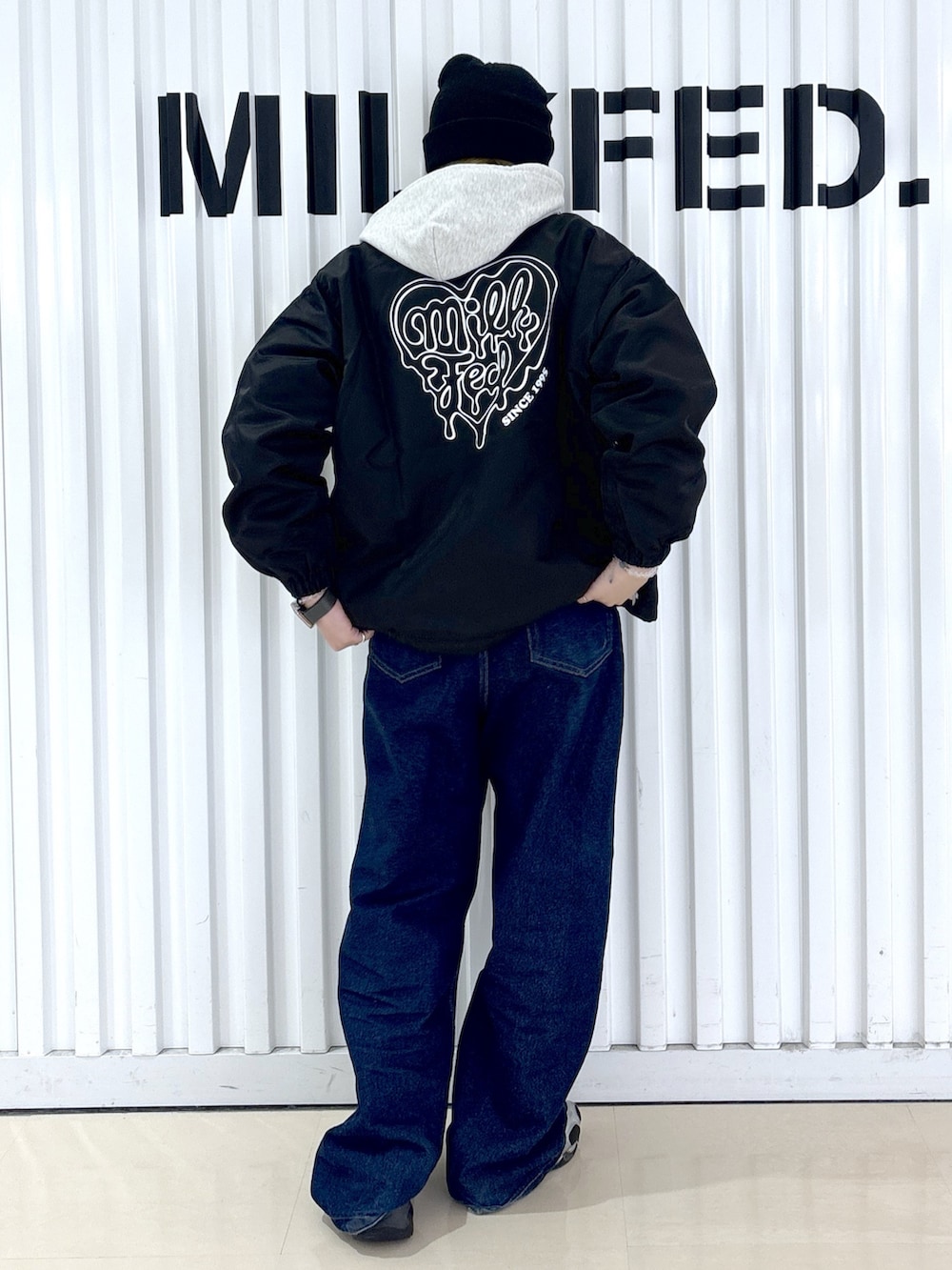 ブルー系のデニムパンツ、ブラック系のブルゾンを着用したレディースの冬コーディネートの2枚目の写真