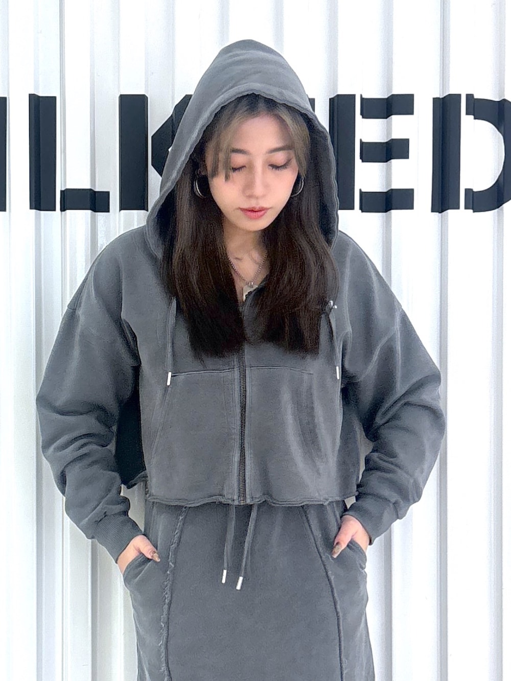 ブラック系のパーカー、ブラック系のスカートを着用したレディースの冬コーディネートの6枚目の写真