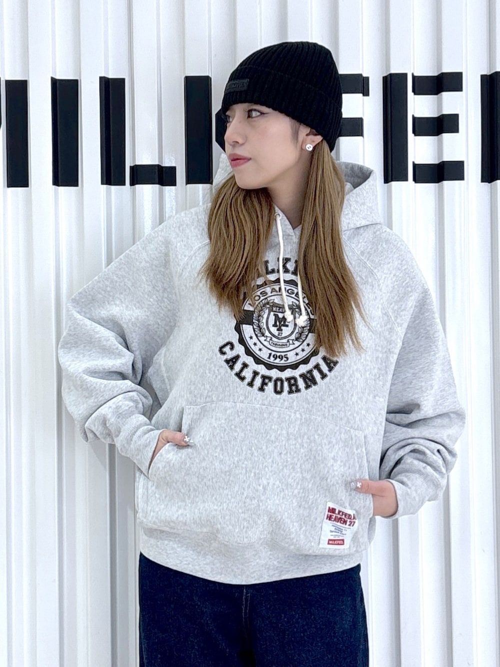 ブラック系のブルゾン、ブルー系のデニムパンツ、グレー系のパーカーを着用したレディースの冬コーディネートの7枚目の写真