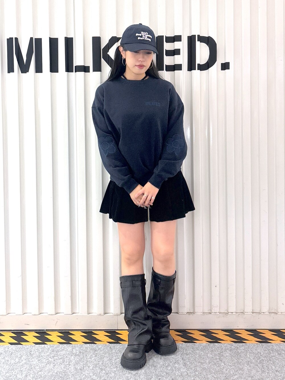 レッド系のスウェット、ホワイト系のベスト、ブラック系のその他パンツを着用したレディースの秋コーディネートの6枚目の写真