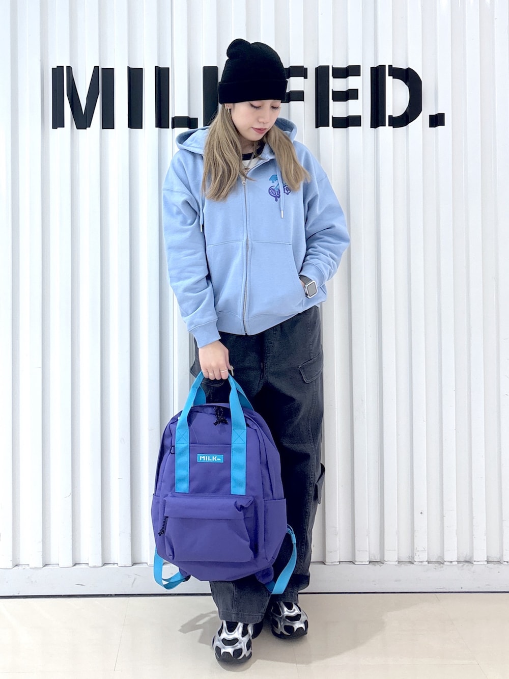 ブラック系のその他パンツ、ブルー系のパーカー、パープル系のバックパック/リュックを着用したレディースの冬コーディネートの2枚目の写真