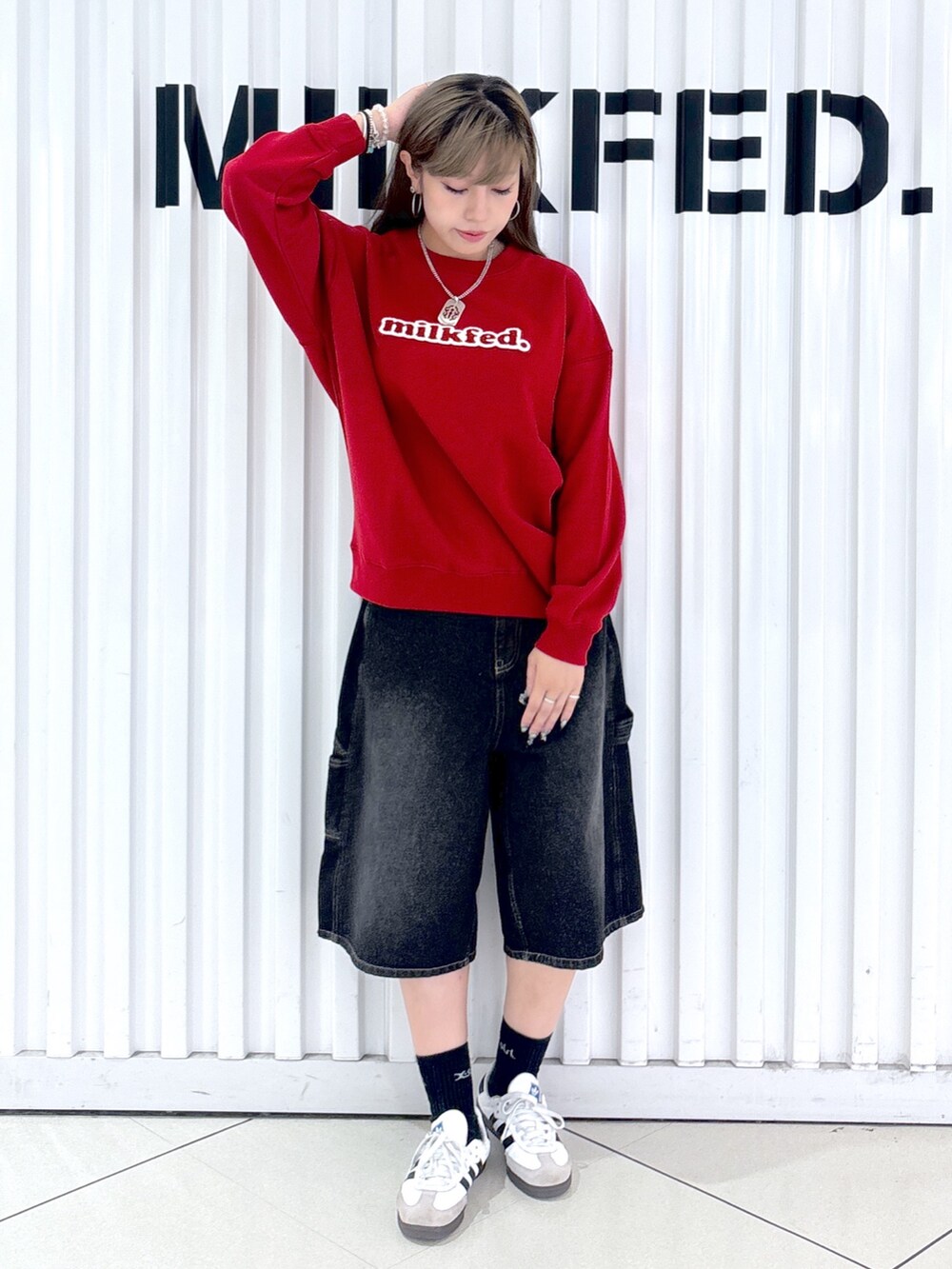 レッド系のスウェット、ホワイト系のデニムパンツ、レッド系のバックパック/リュックを着用したレディースの秋コーディネートの4枚目の写真