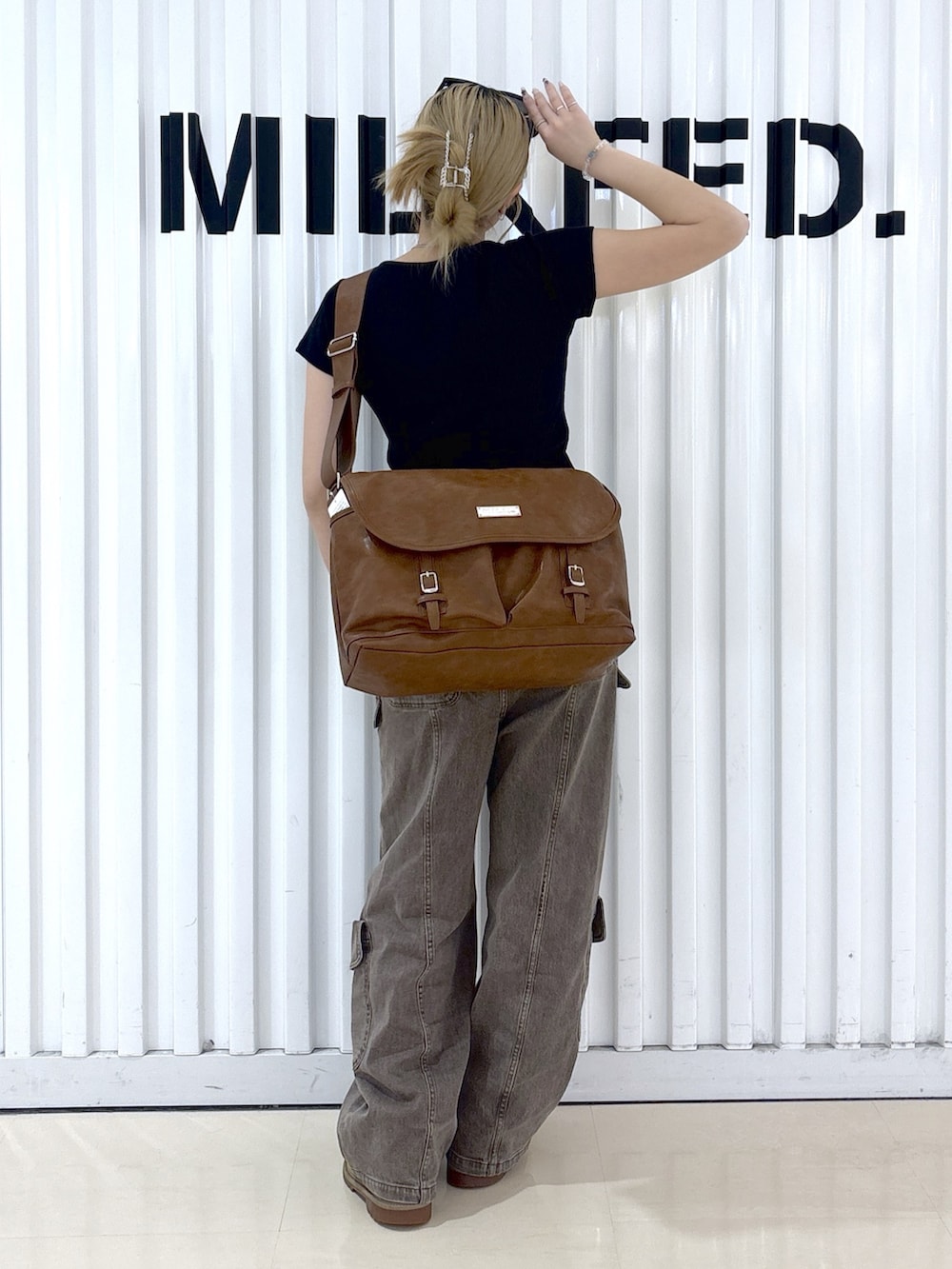 ブラウン系のその他パンツ、ブラック系のTシャツ/カットソー、ブラウン系のショルダーバッグを着用したレディースの春コーディネートの2枚目の写真