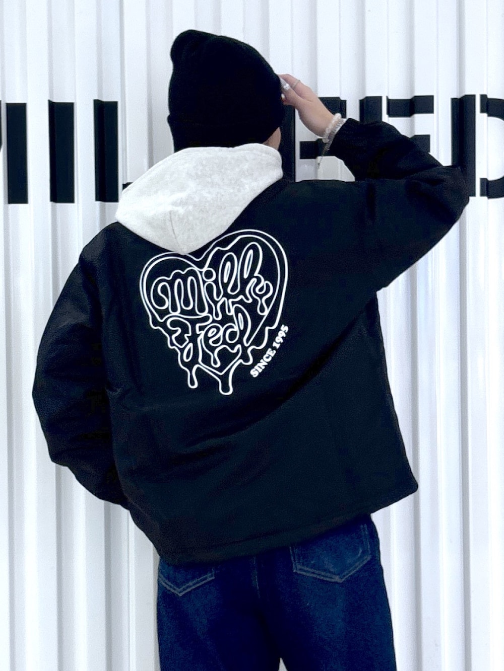 ブルー系のデニムパンツ、ブラック系のブルゾンを着用したレディースの冬コーディネートの4枚目の写真