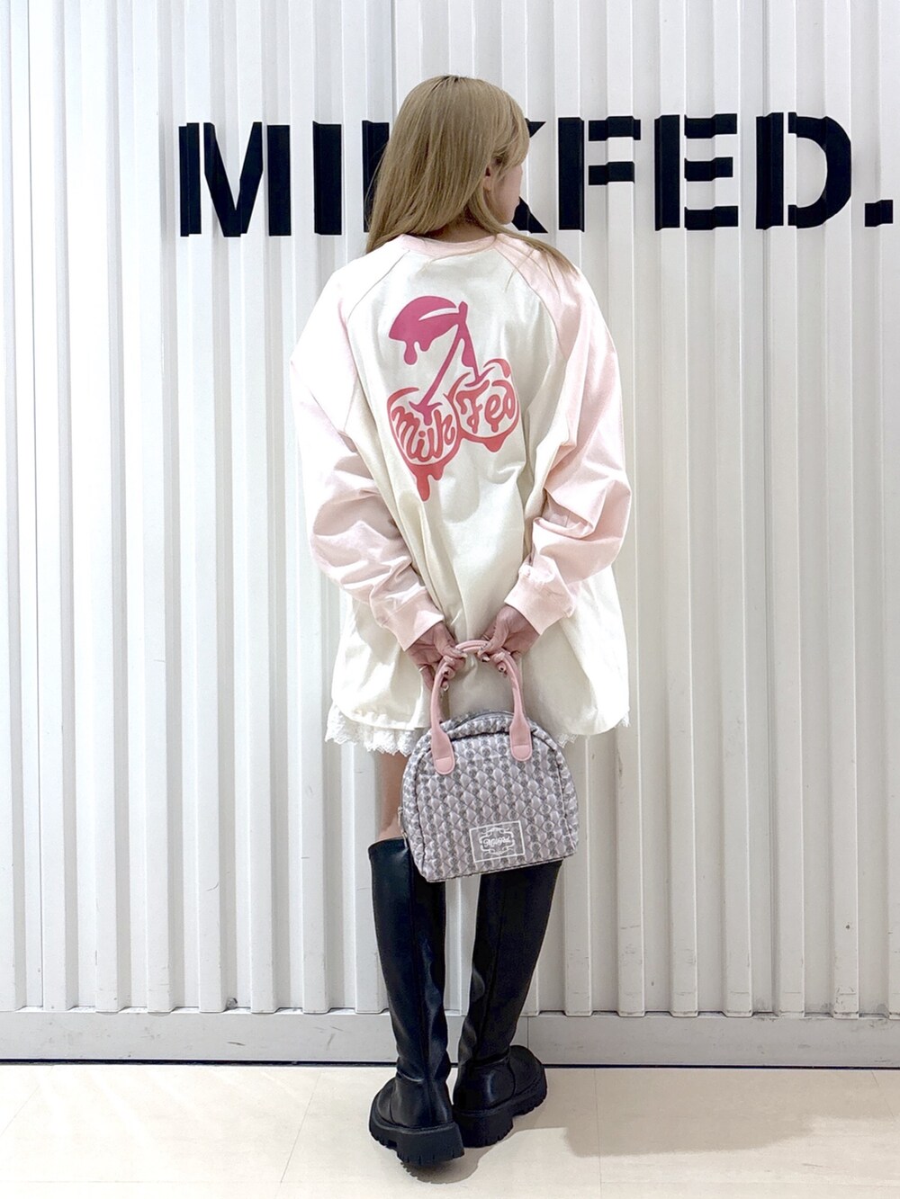 ホワイト系のTシャツ/カットソー、ホワイト系のスカート、グレー系のハンドバッグを着用したレディースの春コーディネートの2枚目の写真